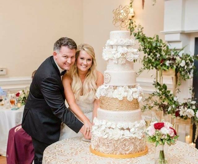 Couple cutting tiered wedding cake