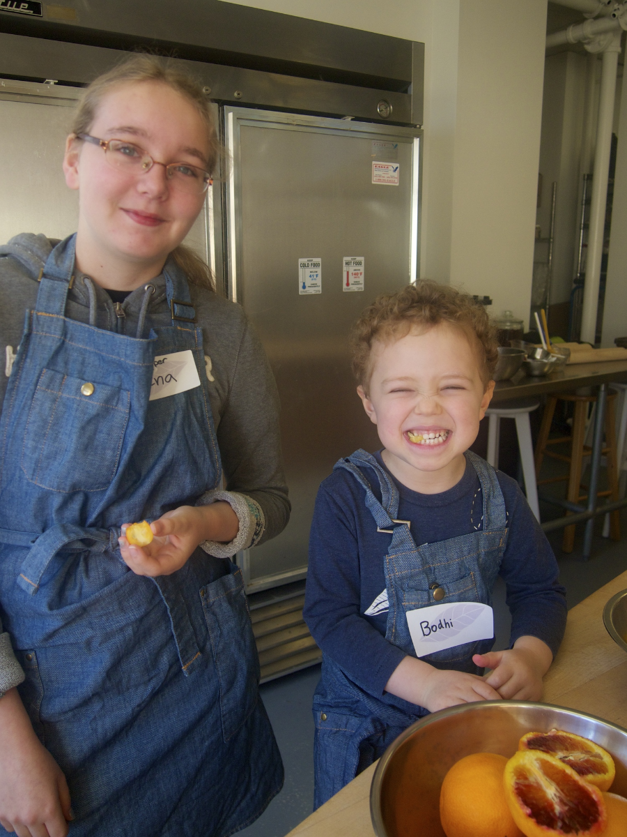 Enjoying kumquats: Jr. Chef Helper Elena with Bodhi
