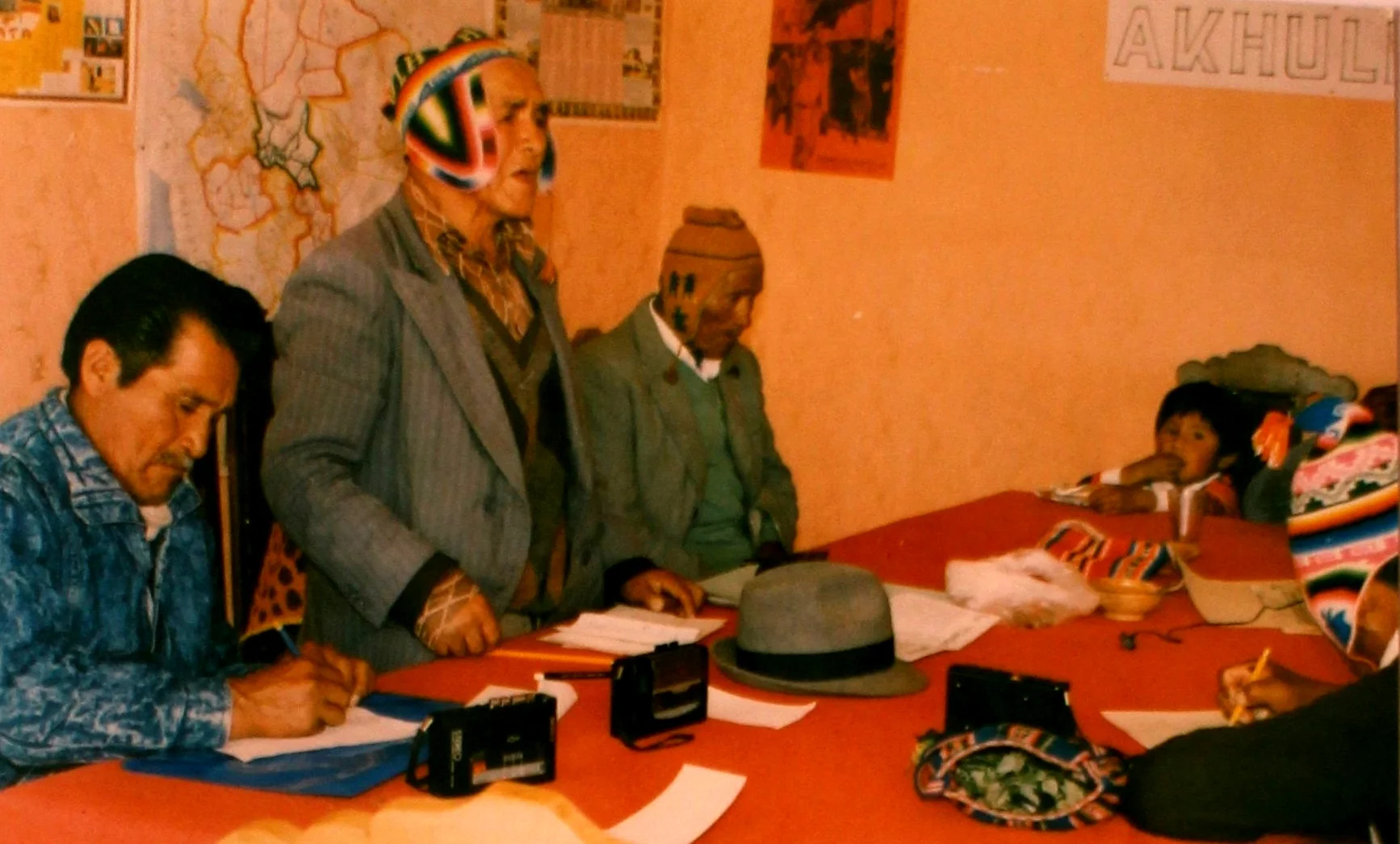 Indigenous leader Andrés Jach’aqullu (standing) shares oral histories on the caciques apoderados movement with the THOA in La Paz in 1990. Courtesy of the Andean Oral History Workshop.