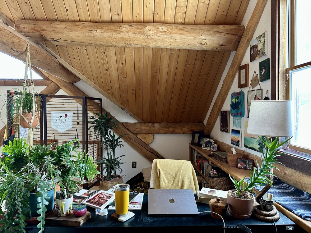 Kelton&rsquo;s writing desk under a log-cabin ceiling