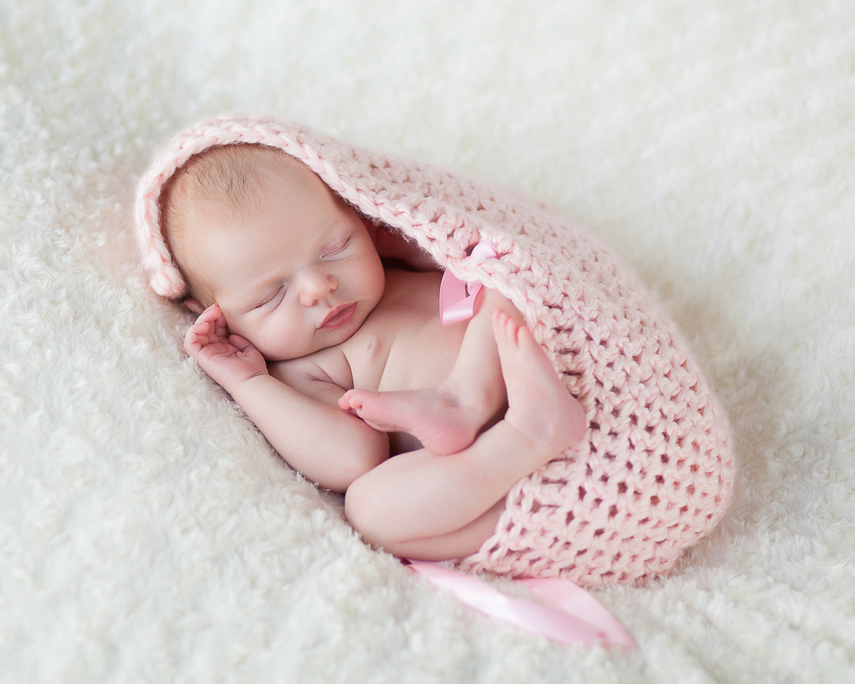 sleeping newborn wrapped in pink