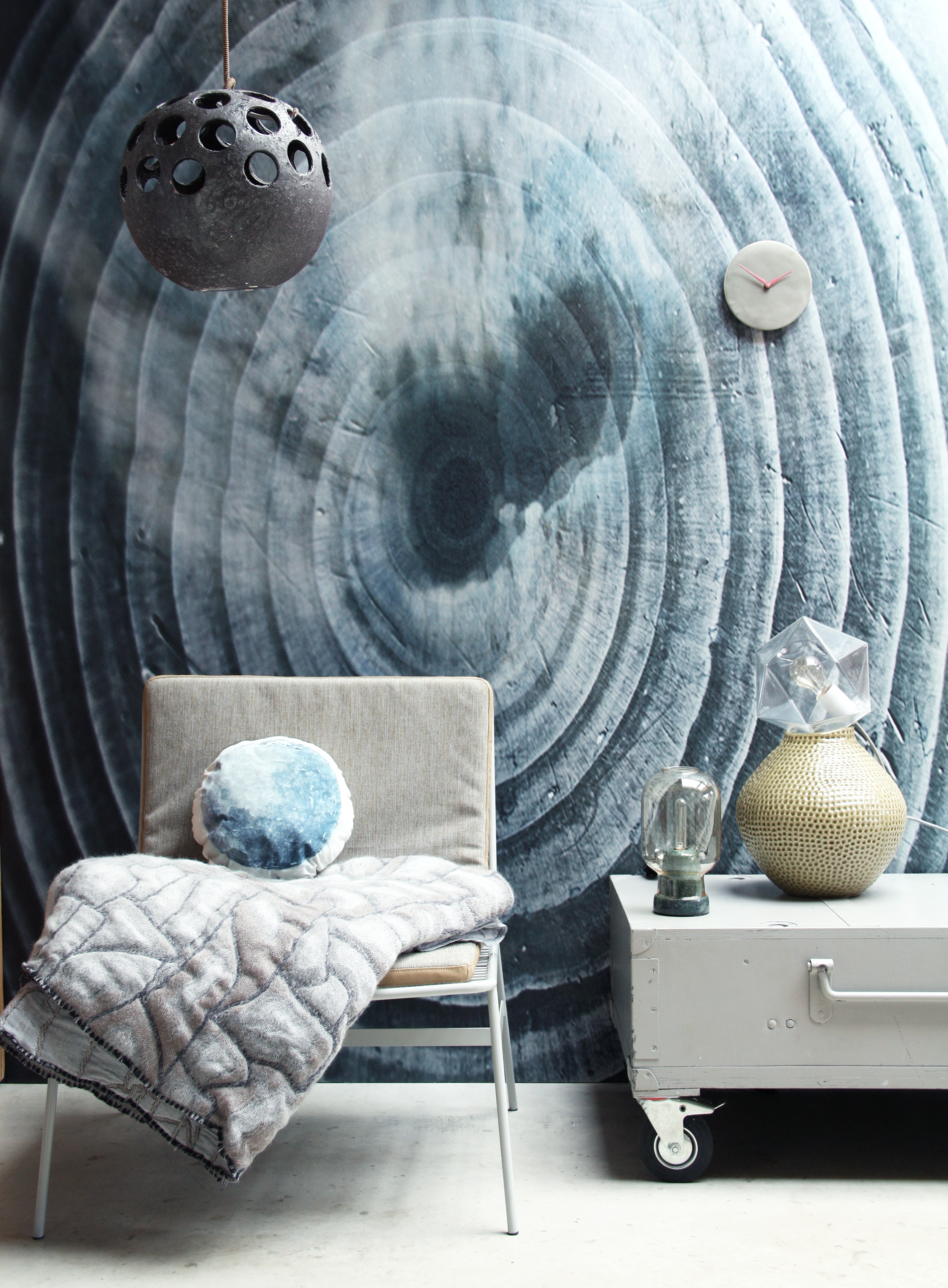 Behang via Repro , ontwerp StyleCookie, Stoel van HK living , Plaid van Studio Nienke Hoogvliet , Kussen met 'maan' print van StyleCookie propshop, Kast van Combitex , Lamp van &Klevering , Okergele vaas van Broste , Glazen diamantlamp van HK Living , Klok van...., Vintage lamp StyleCookie propshop