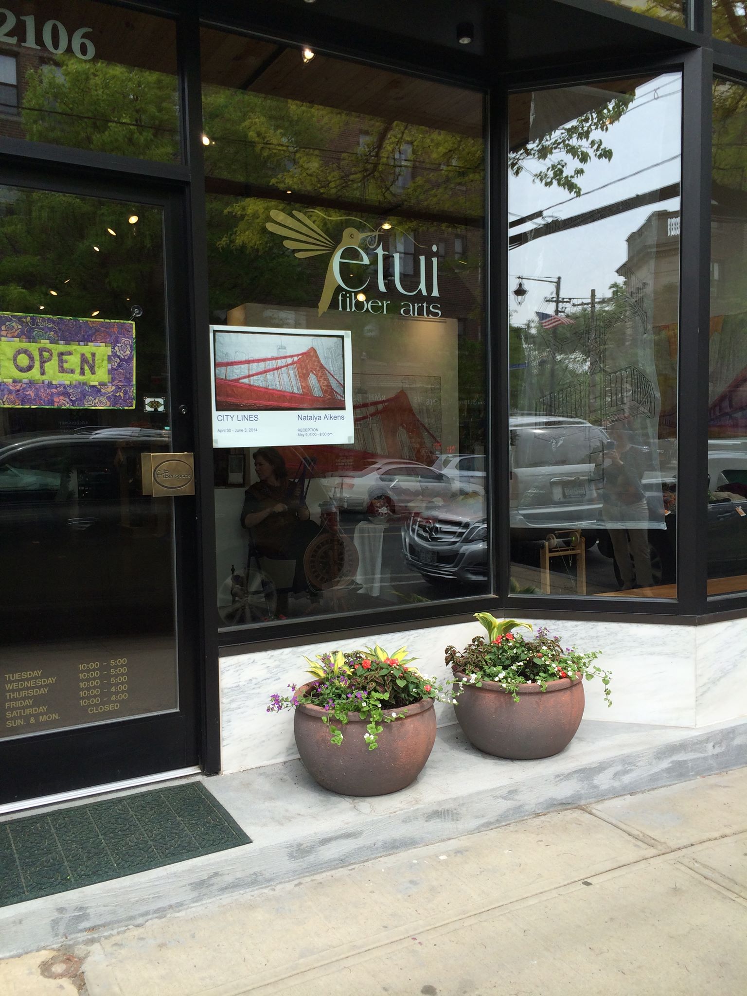 Spinning behind the window of Etui Fiber Arts Gallery.