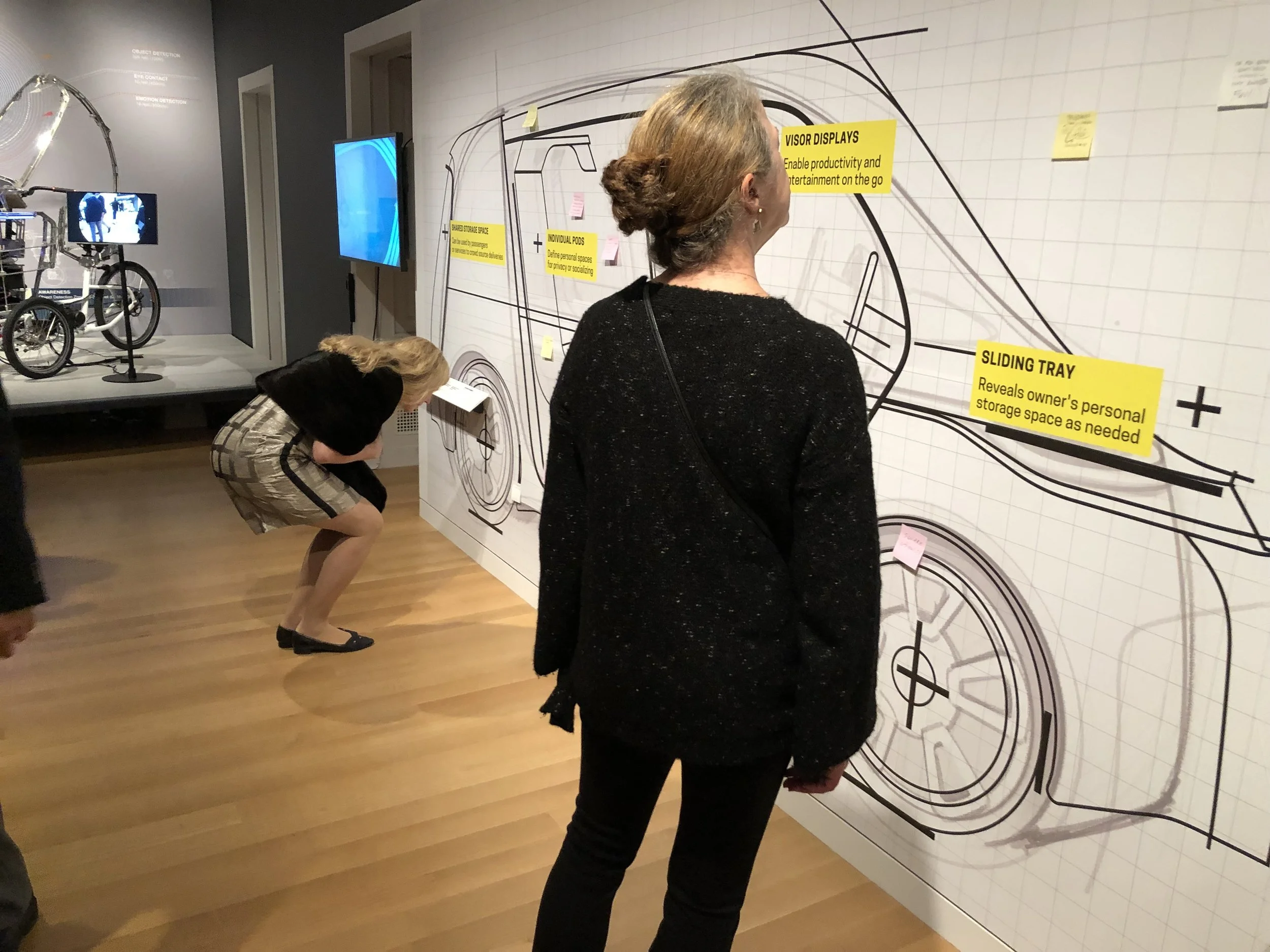 Visitors are prompted to capture their own hopes, needs and desires for future mobility on post-it notes and to place them upon a life-sized sketch of a vehicle designed to support shared mobility.
