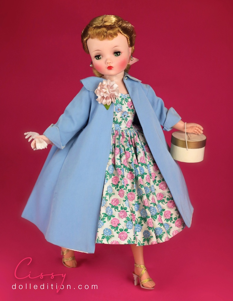 Cissy is wearing a 1958 clover and floral print cotton dress No. 22-25. Trimmed with Val Lace and sprinkled with rhinestones, it is paired with high heeled shoes from Premiere. Accented with multi colored stones in the heels and gold metalic elastic straps - all the rage in Paris. Mid Century fashion had a fascination with sparkle and an element of excess. Struggling since the 1930s, Americans wanted to be entertained and even amused by their mid-century fashion statements .