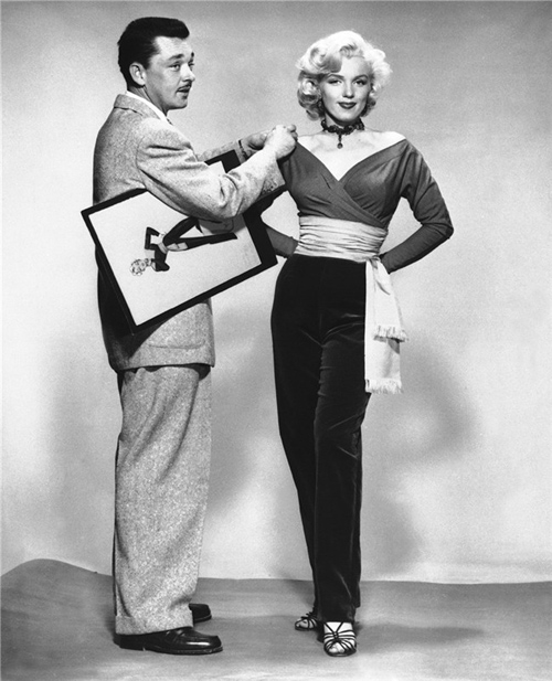 Marilyn Monroe with costume designer William Travilla with sketch for pants costume for Gentlemen Prefer Blonds.