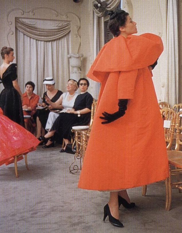 Cristobal Balancinga and his interpretation of the swing coat as an evening-coat... Love the ladies in the background still in their Mamie Eisenhower mid west fashion.