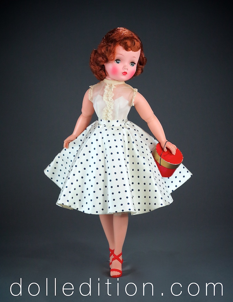 Cissy wears her No. 22-54 circle skirt with navy polka dots with a sleeveless organdy blouse with lace detail .