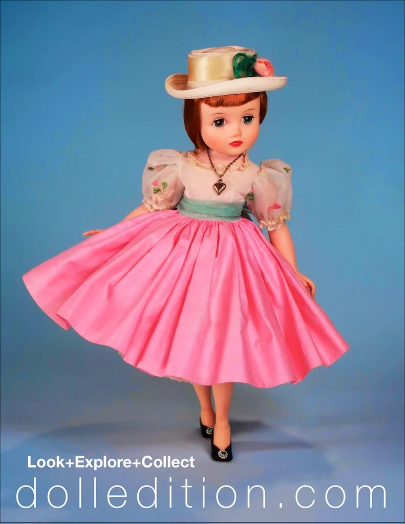 Looking demure in her party frock of cotton and organdy top with embroidered details, Italian straw hat accented with a feathers and a pink rose.