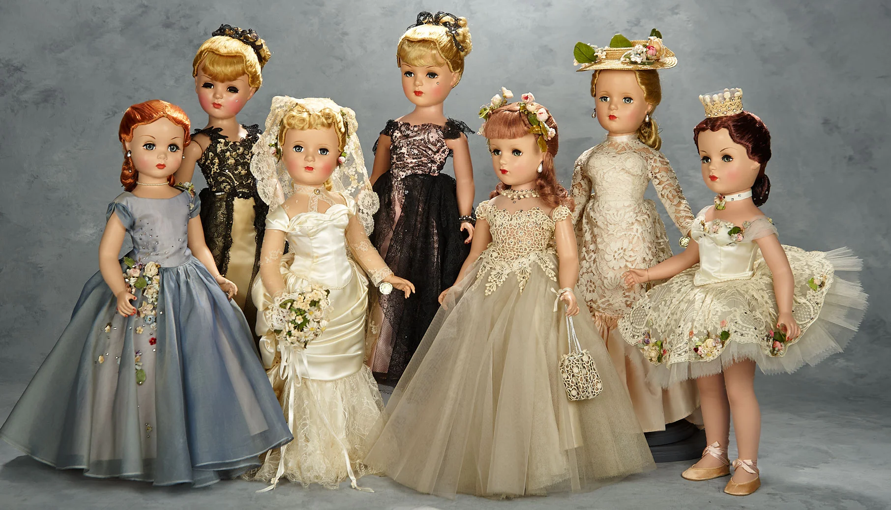 21 inch set of 1951 Mystery Portrait Dolls by Madame Alexander:Front, left to right: Judy, A Debutante; Victoria, a godey bride; Deborah, a Debutante; Ballets des Fleurs Top, left to right: Champs-Elysées with golden sheath, Champs-Elysées with pink sheath; Pink Champagne, inspired by a Renoir painting