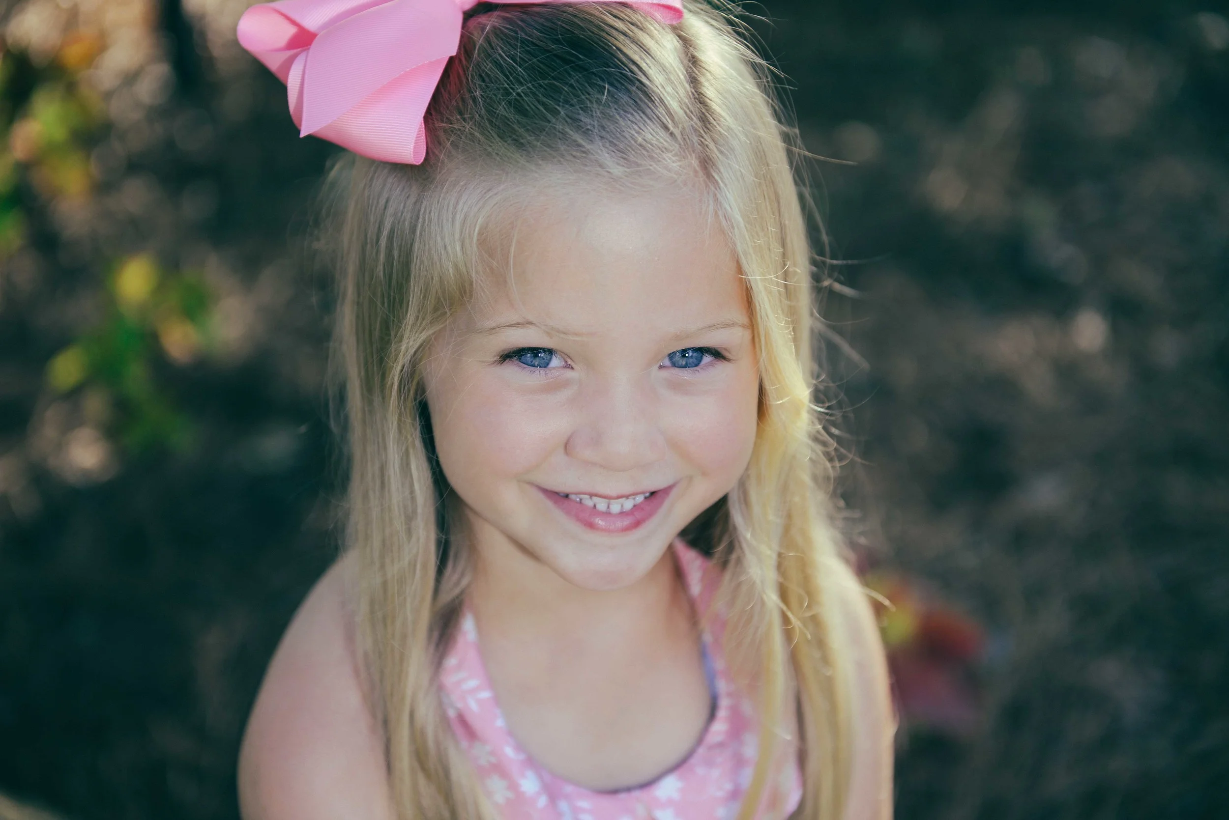 smiling little girl with pink bow