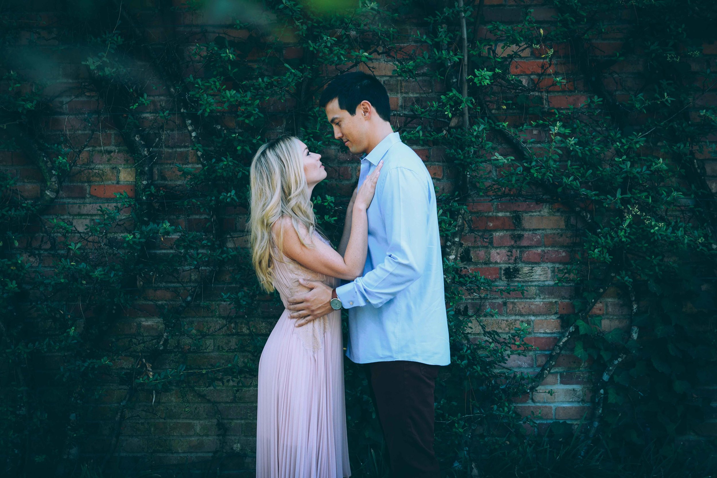 couple in front of vines on brick