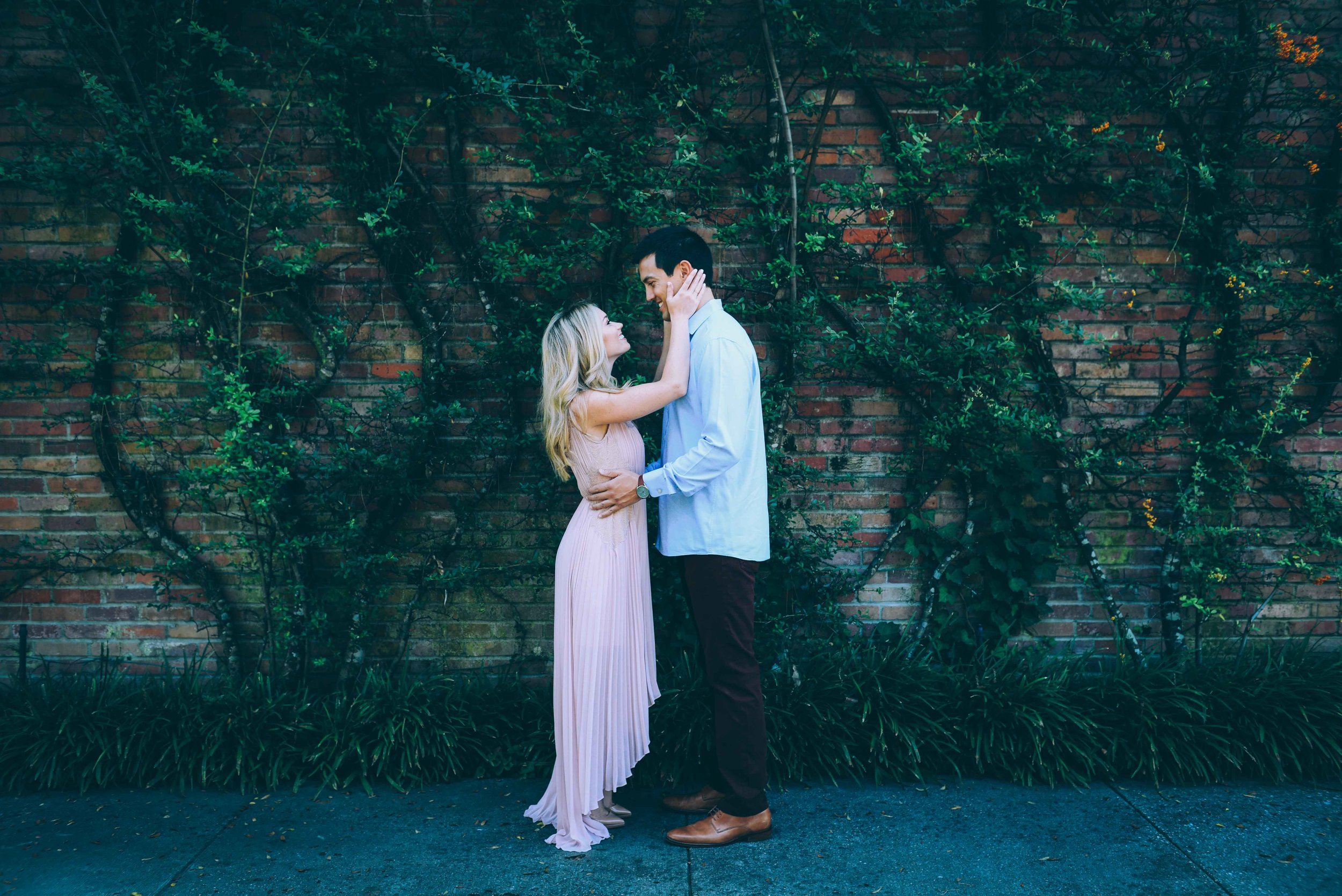 couple in front of vines on brick