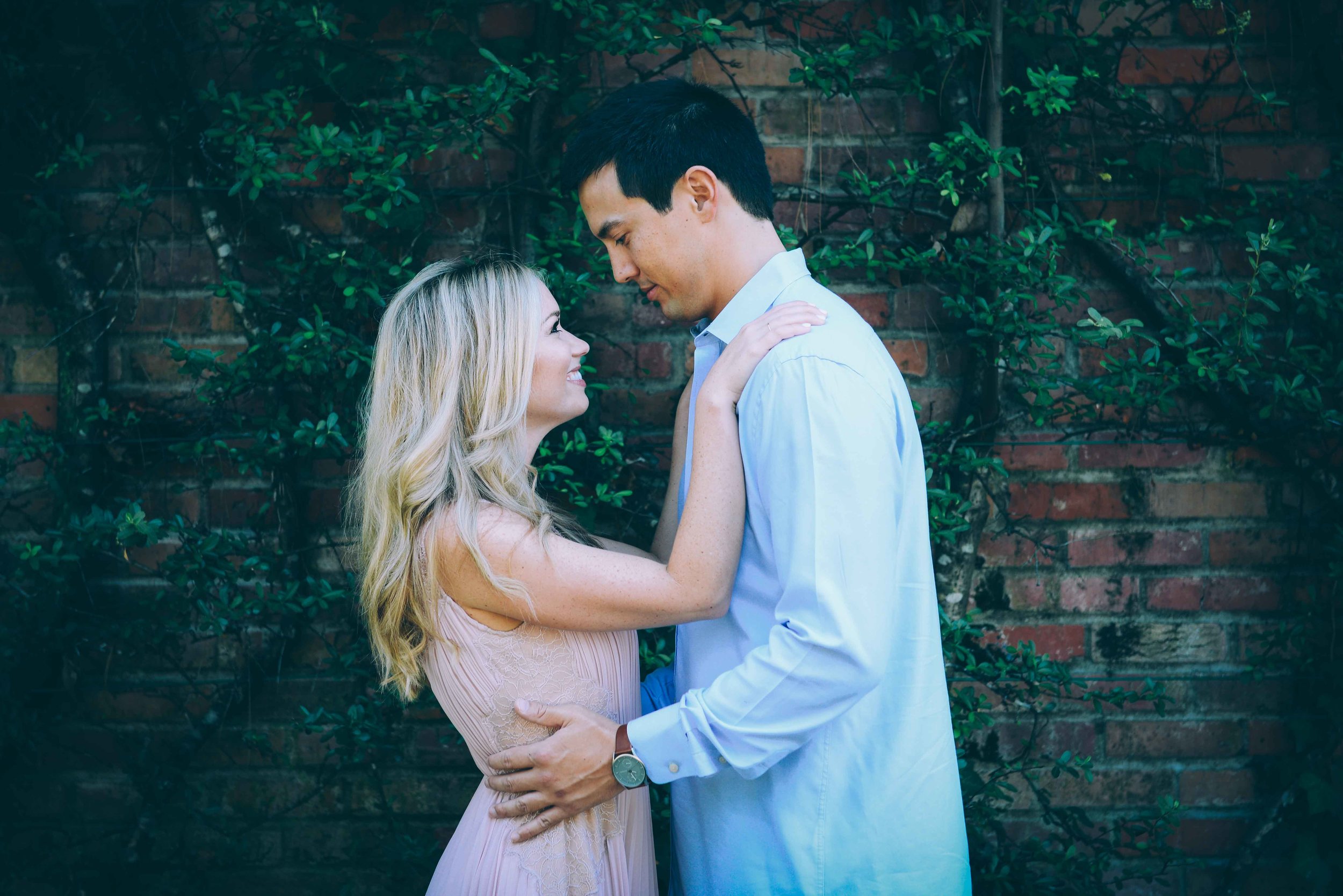 couple in front of vines on brick