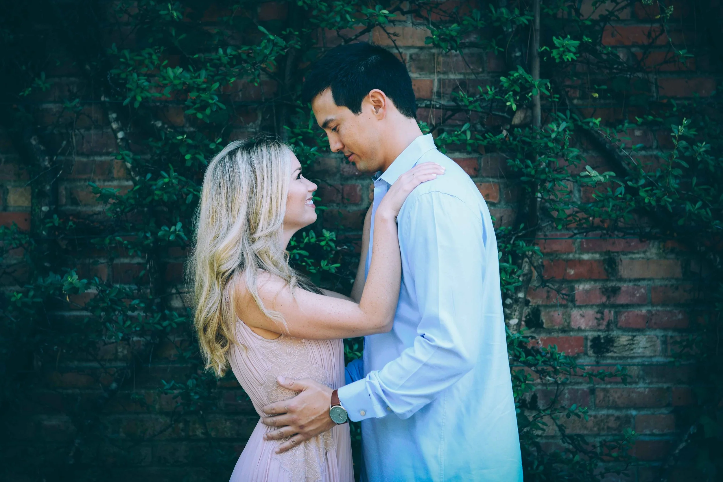 couple in front of vines on brick
