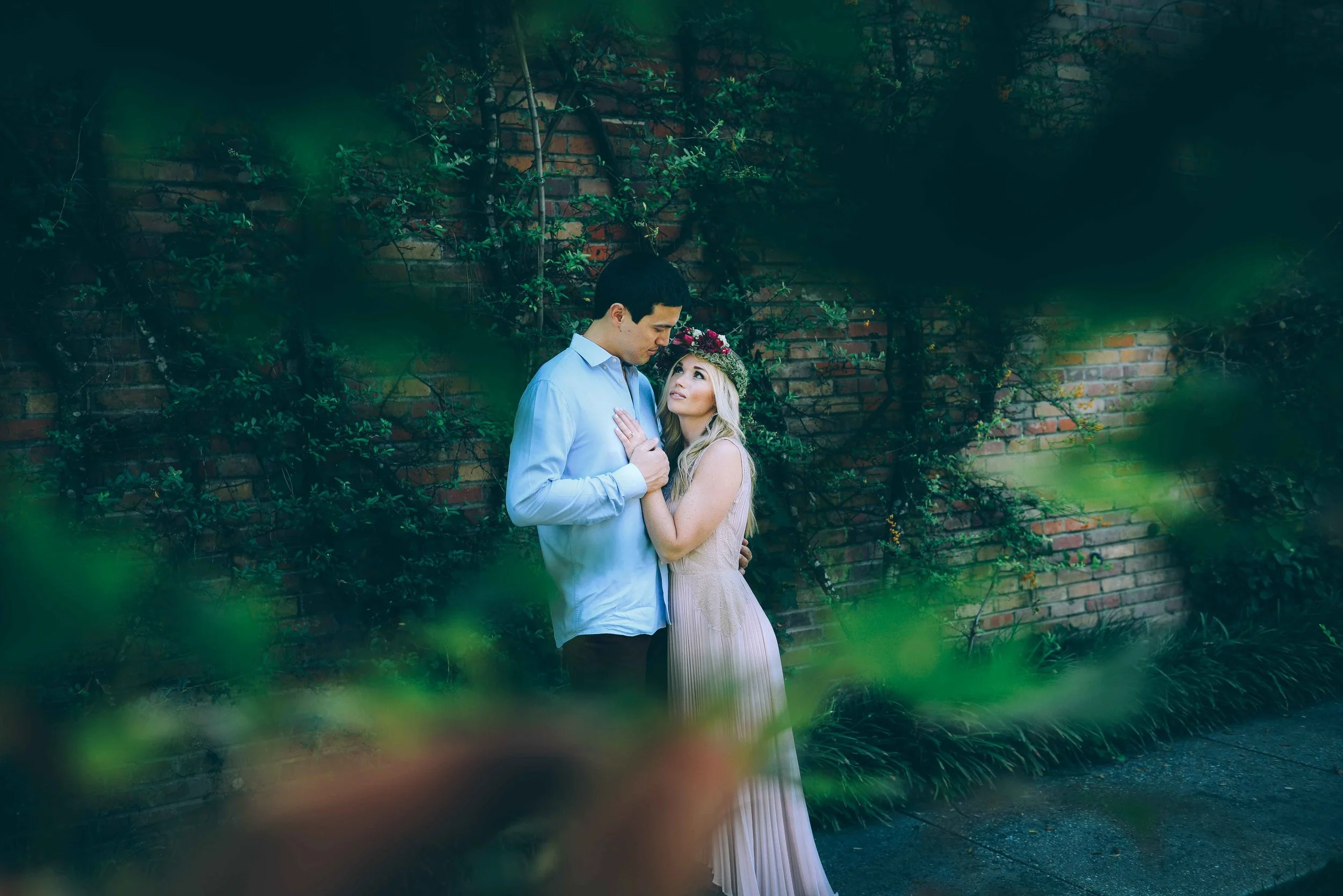 couple in front of vines on brick