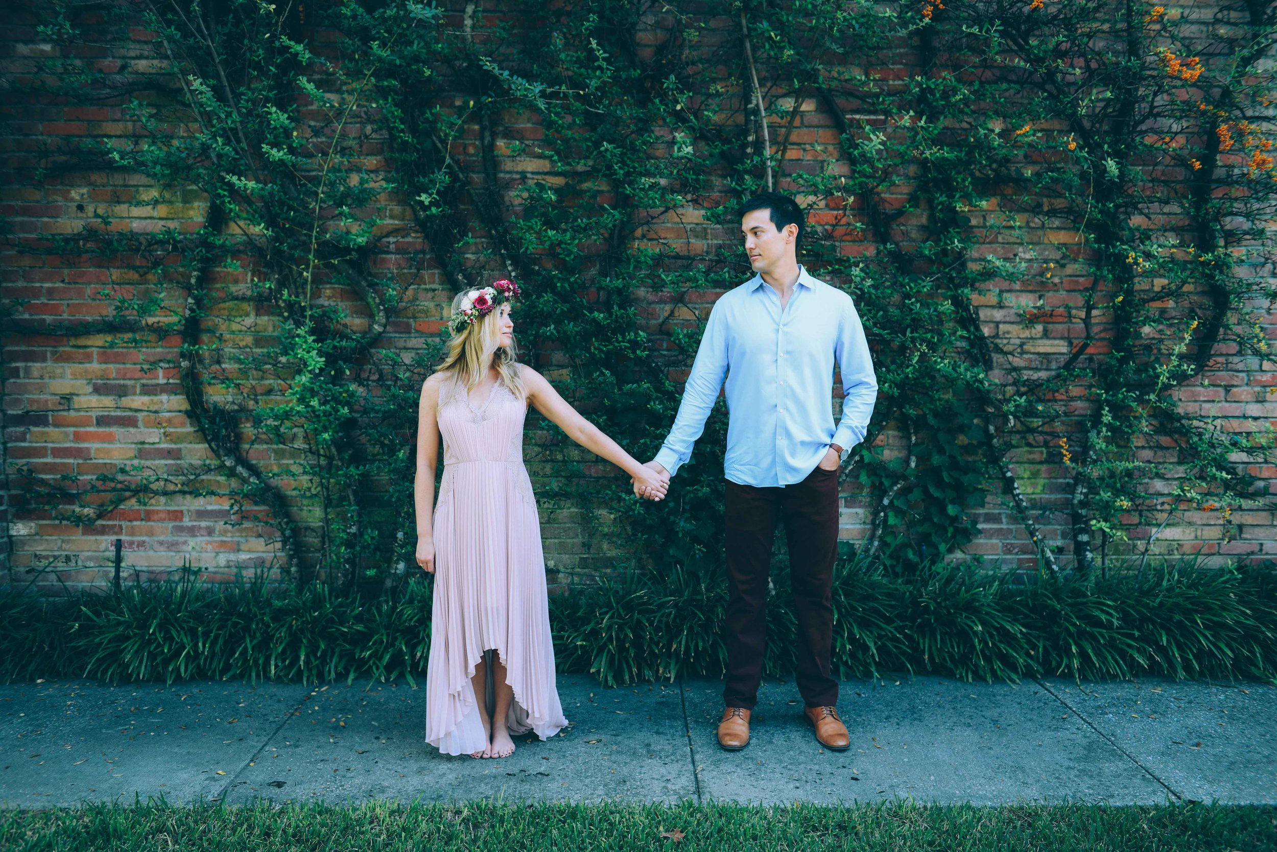 couple in front of vines on brick