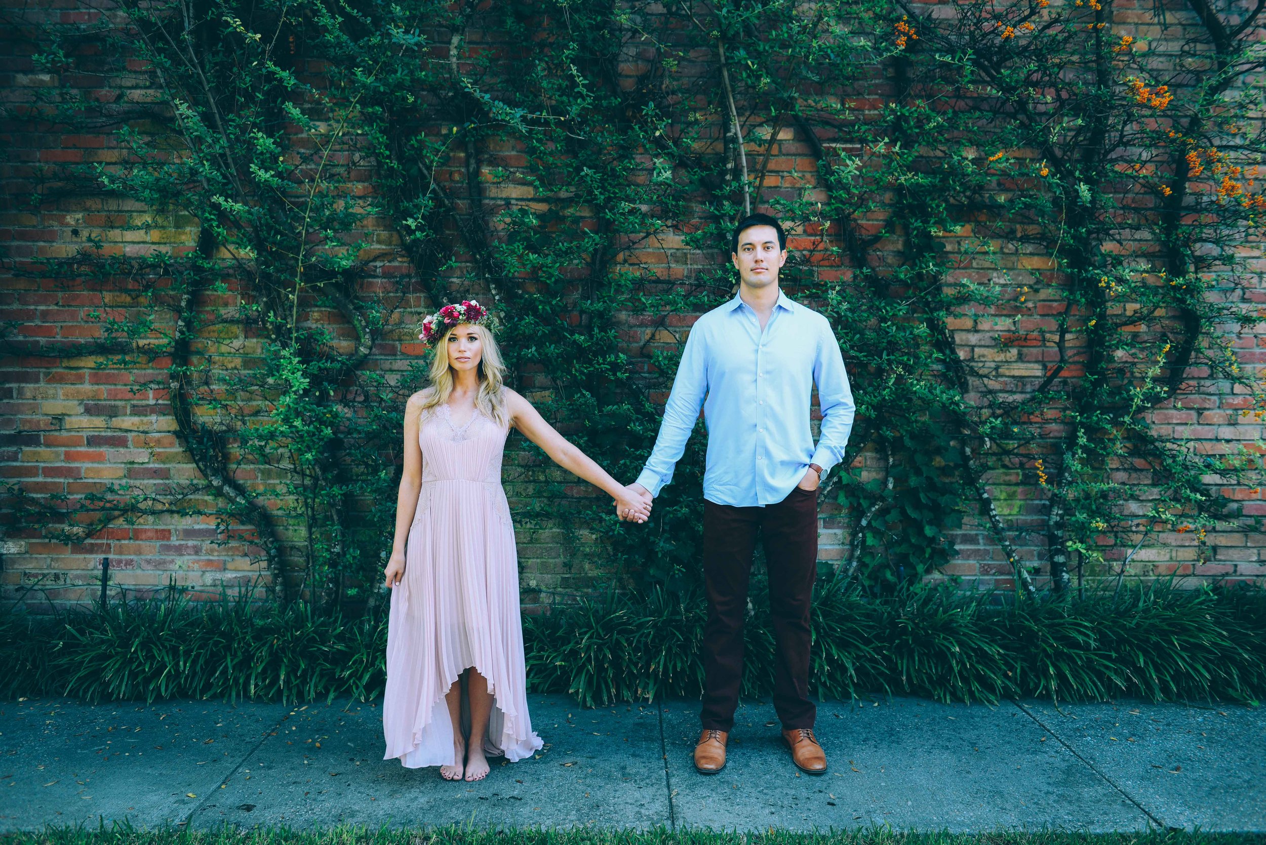 couple in front of vines on brick