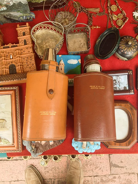 Two leather flasks with aluminum shot glasses tucked into the cap. And do you see how the flasks are sitting on something whose toes are poking out. Just like my husband's shoes are poking out. Let's drink to that!