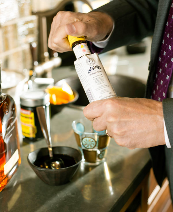 Add two dashes Angostura bitters and a 1/2 teaspoon of simple syrup to a lowball glass.