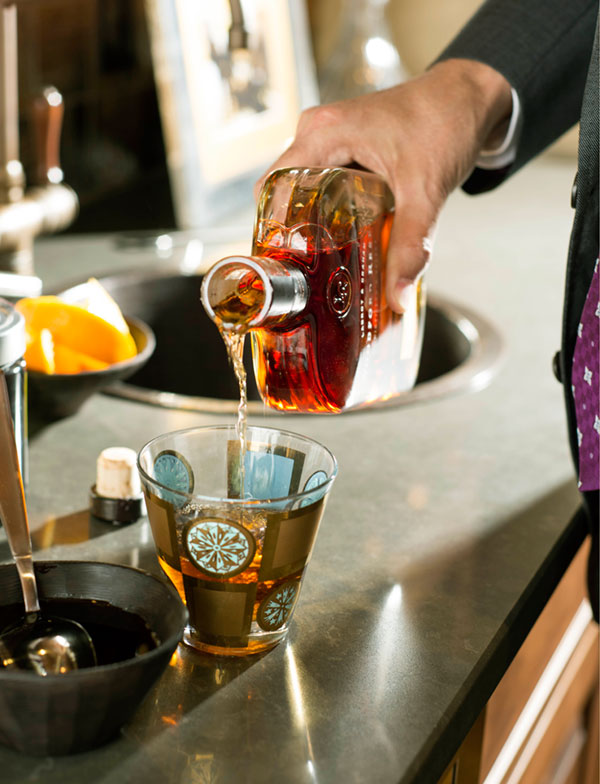 Pour a hefty serving of bourbon (4 oz.) into a lowball glass.