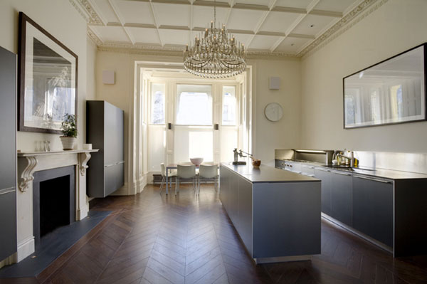 What a kitchen! The house (above), which is located in London, dates from 1870 and was designed by Stephen Fletcher. I love the understated cabinetry, the decadent light fixture, the flooring, and the neutral colors that let the architecture sing. But something is missing, don't you think? A couple of comfy chairs flanking the fireplace. Somewhere for Mrs. Patmore and Daisy to rest their weary legs.
