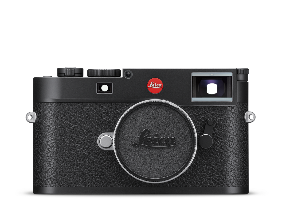 A black Leica camera with a textured grip and silver accents, featuring a large central lens cover with the Leica logo, and a red Leica badge near the top right.