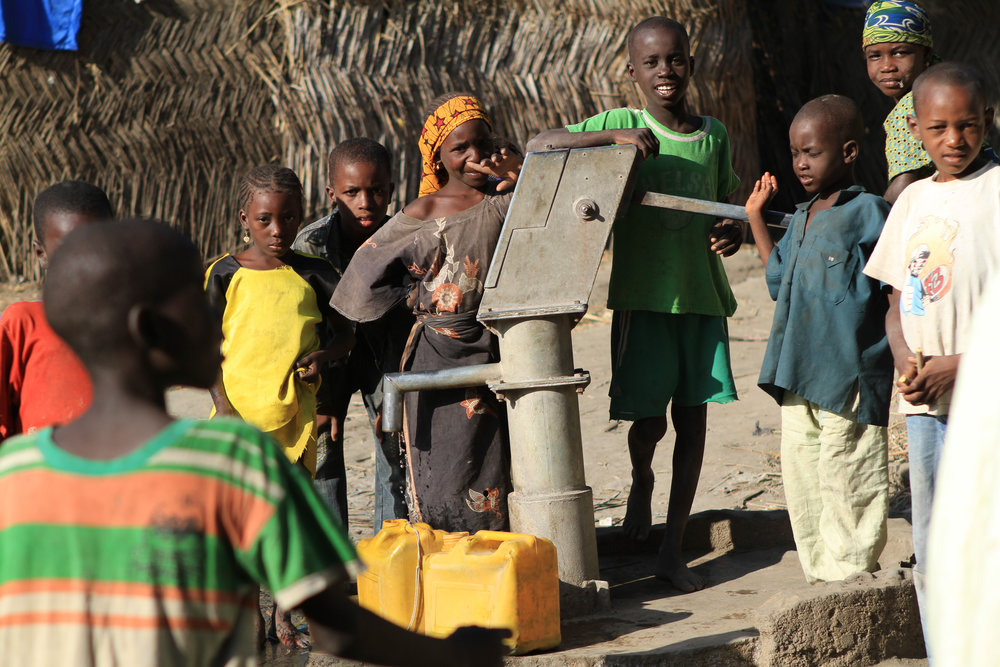  Children gather at the village well.&nbsp; 