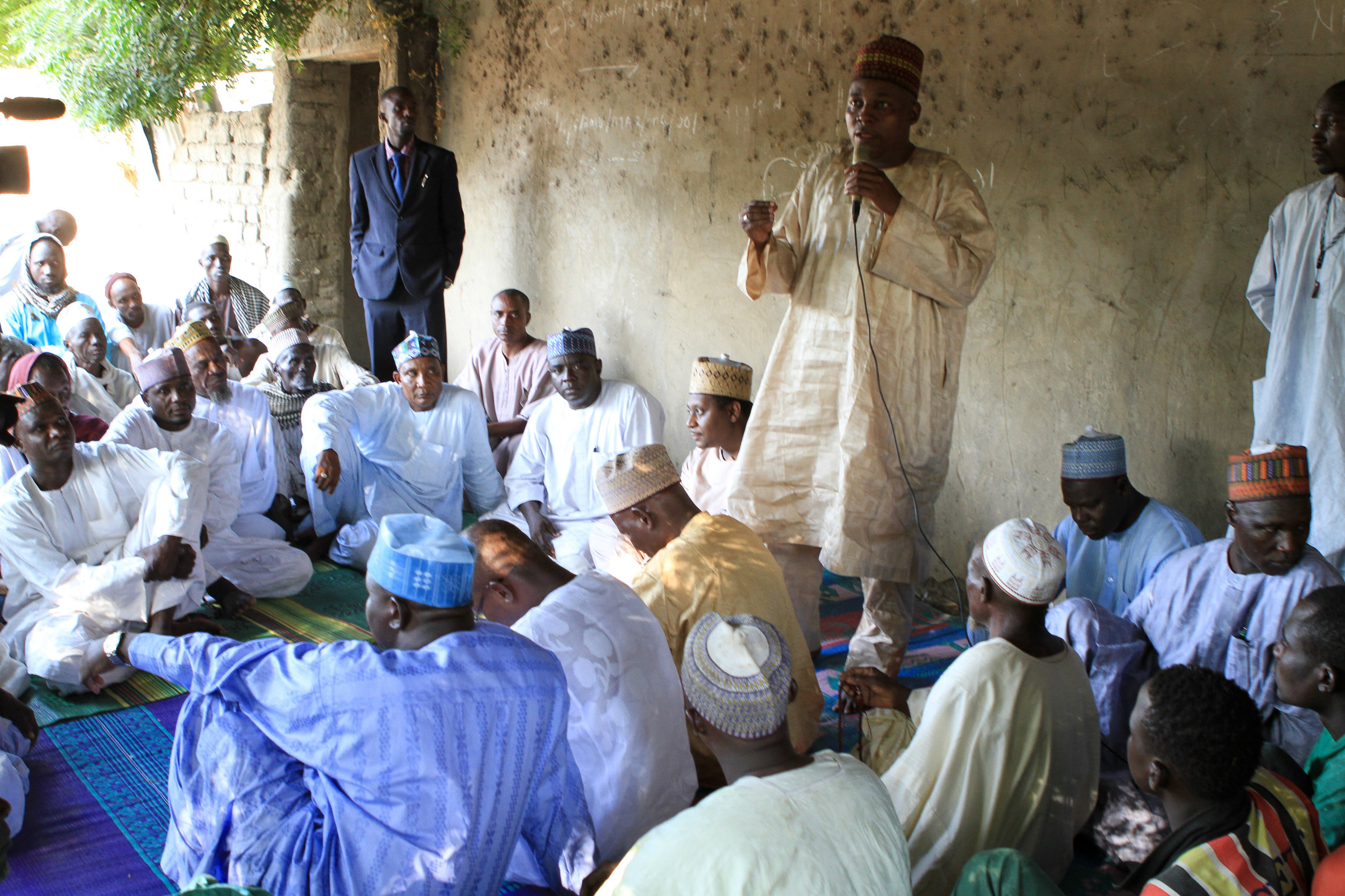 The men gathered around to discuss community needs, and t he health minister promised them a health clinic. 