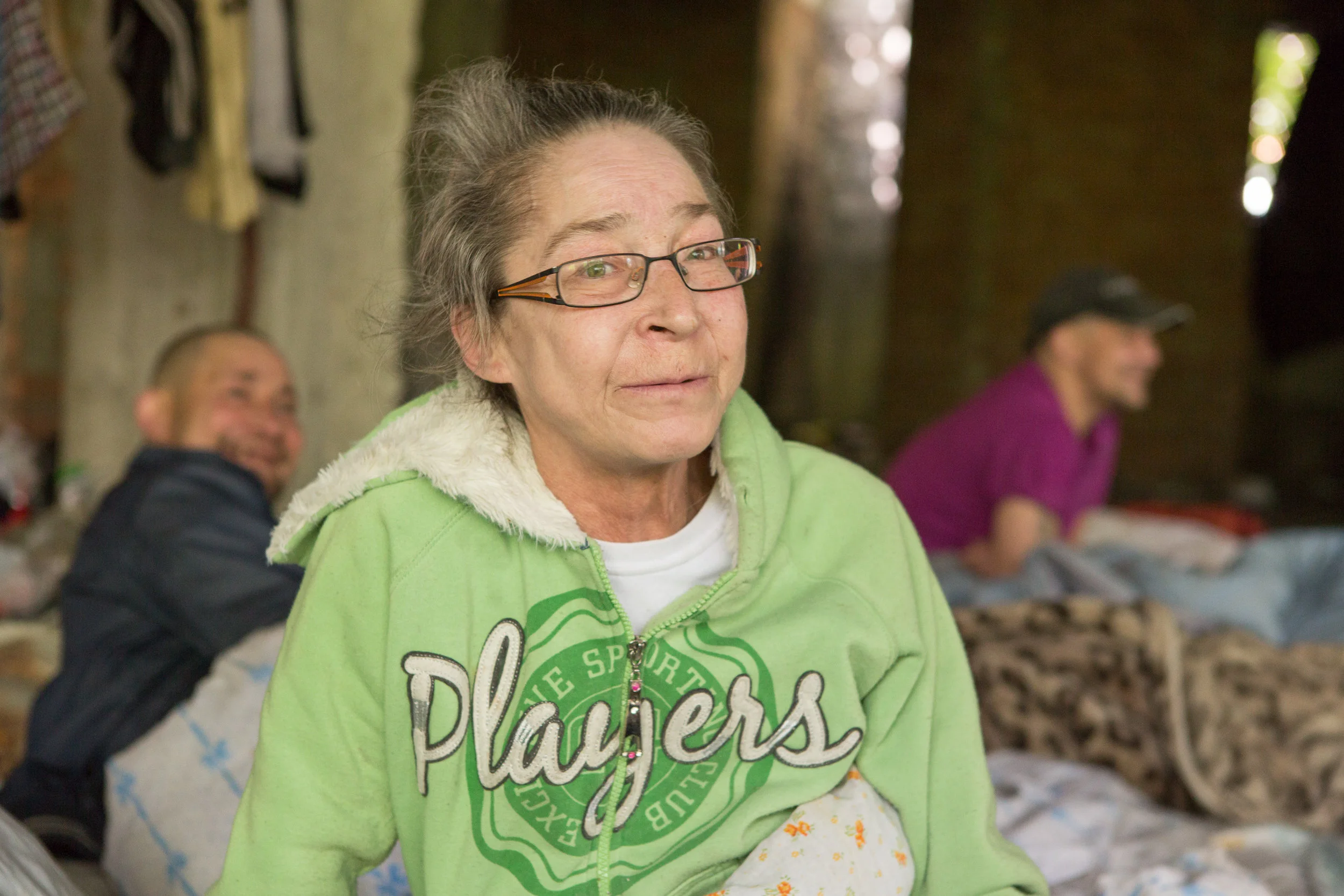 Katerina, 60, spends her days reading in this abandonded building site in Chisinau, Moldova where many people who are homeless gather to rest and sleep. The NGO Act for Involvement helped Katerina finish her treatment for tuberculosis earlier this year. An AFI doctor, Valeriu Coada, checks on Katerina and others who stay here. Valeriu and colleagues from the AFI mobile team regularly take people who are homeless for TB screening.