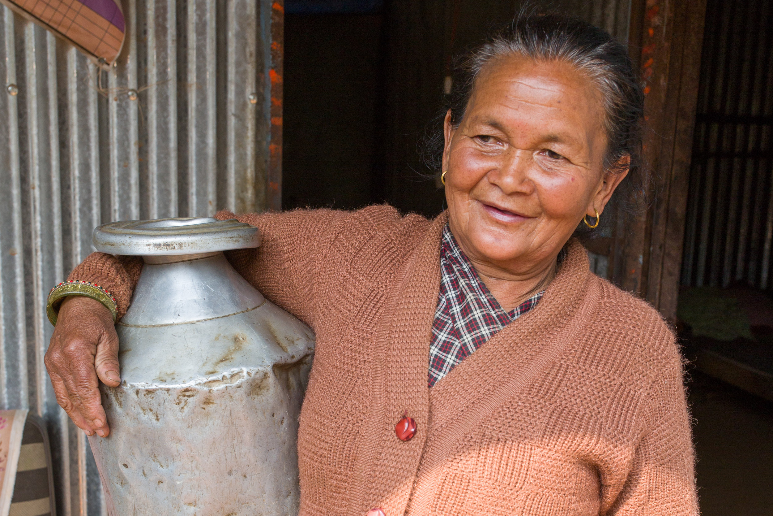 Keshari, a 74-year old widow, with a dented pot she salvaged from her crumbled home. 
