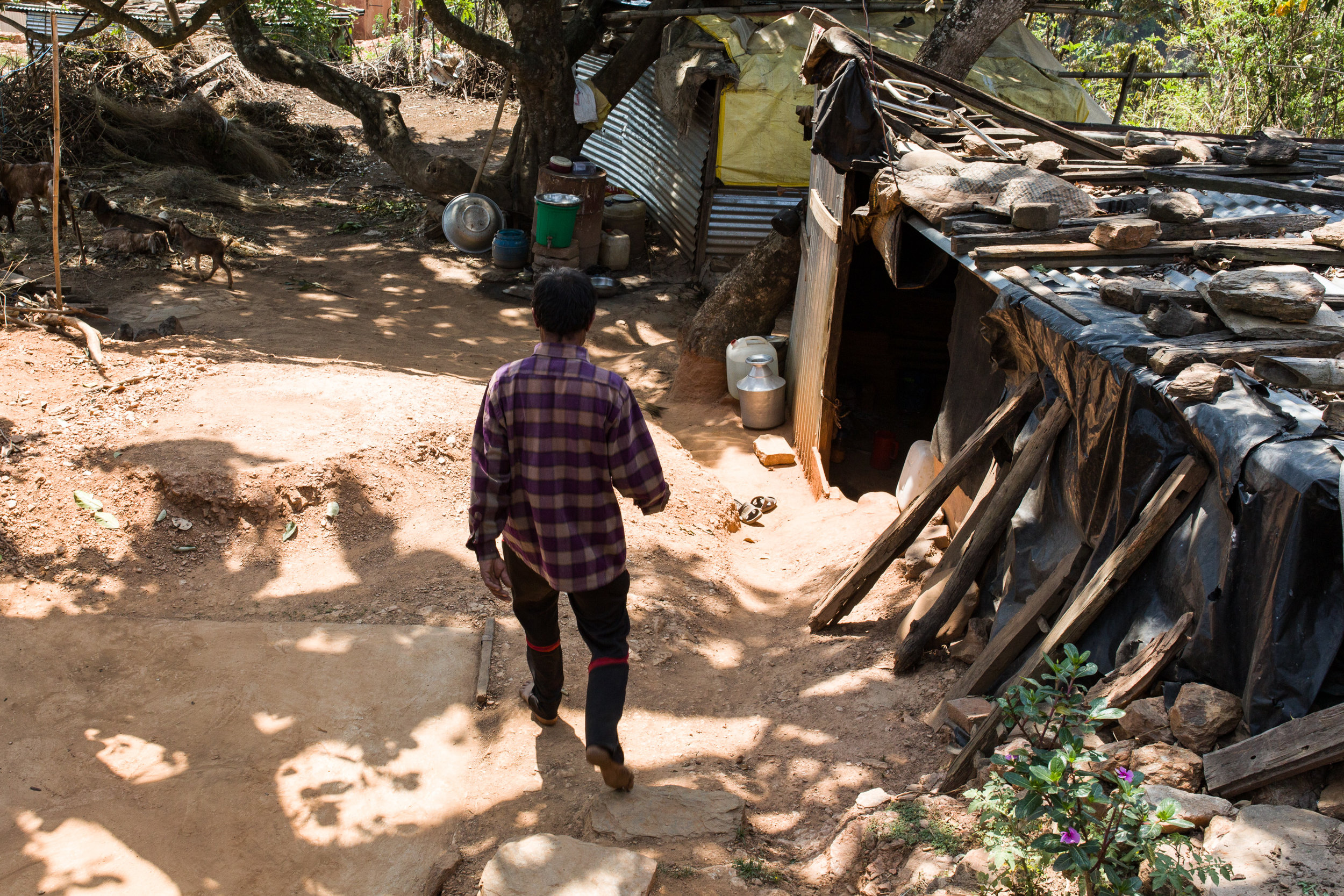 Narayan walks by the makeshift shack he and his family of seven slept in for a year. 