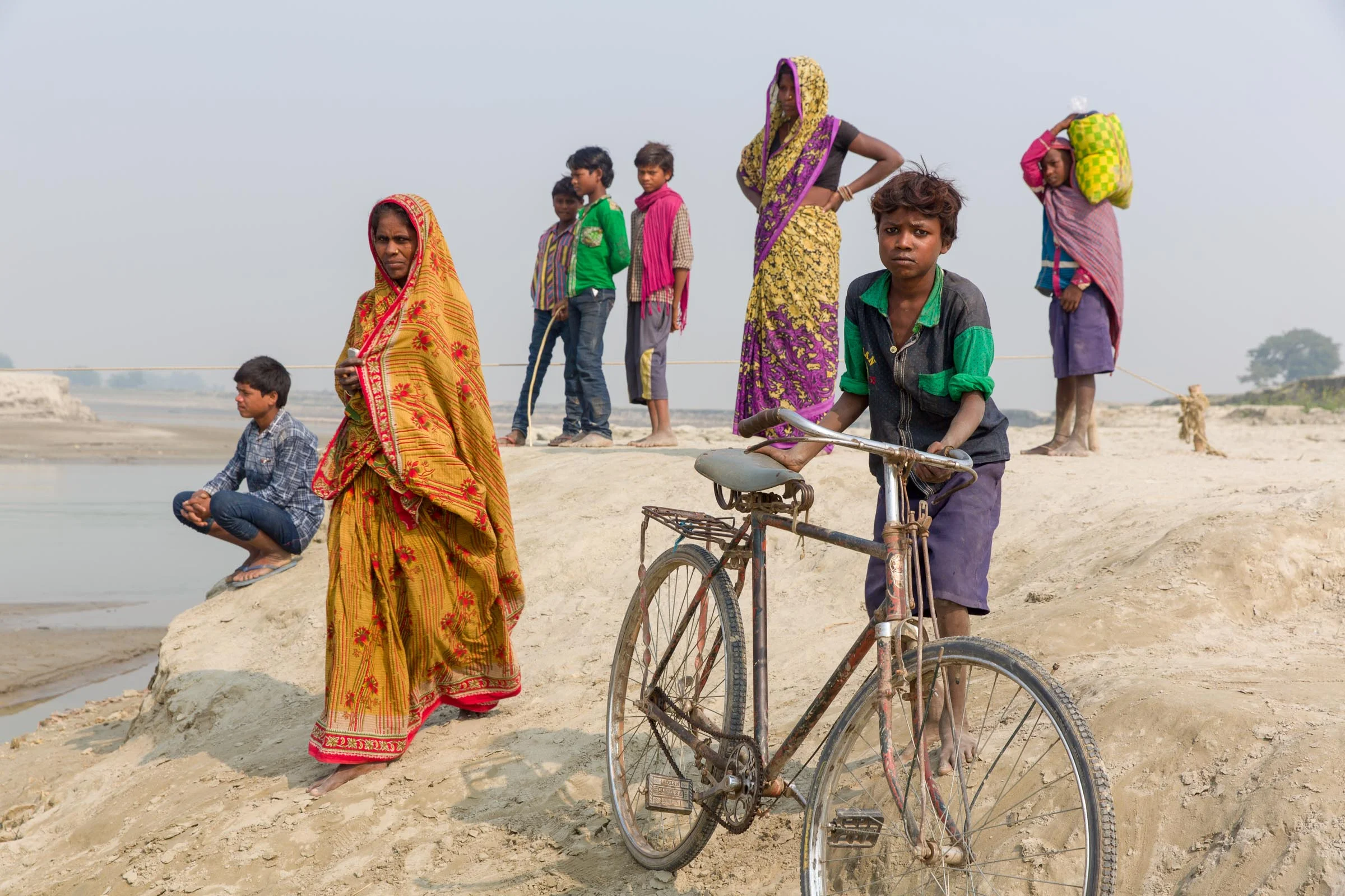 Community members wait for the ferry in the Kosi River Basin area. In the dry season, the region is an endless plain; and in the wet season the waters flood several metres high.  