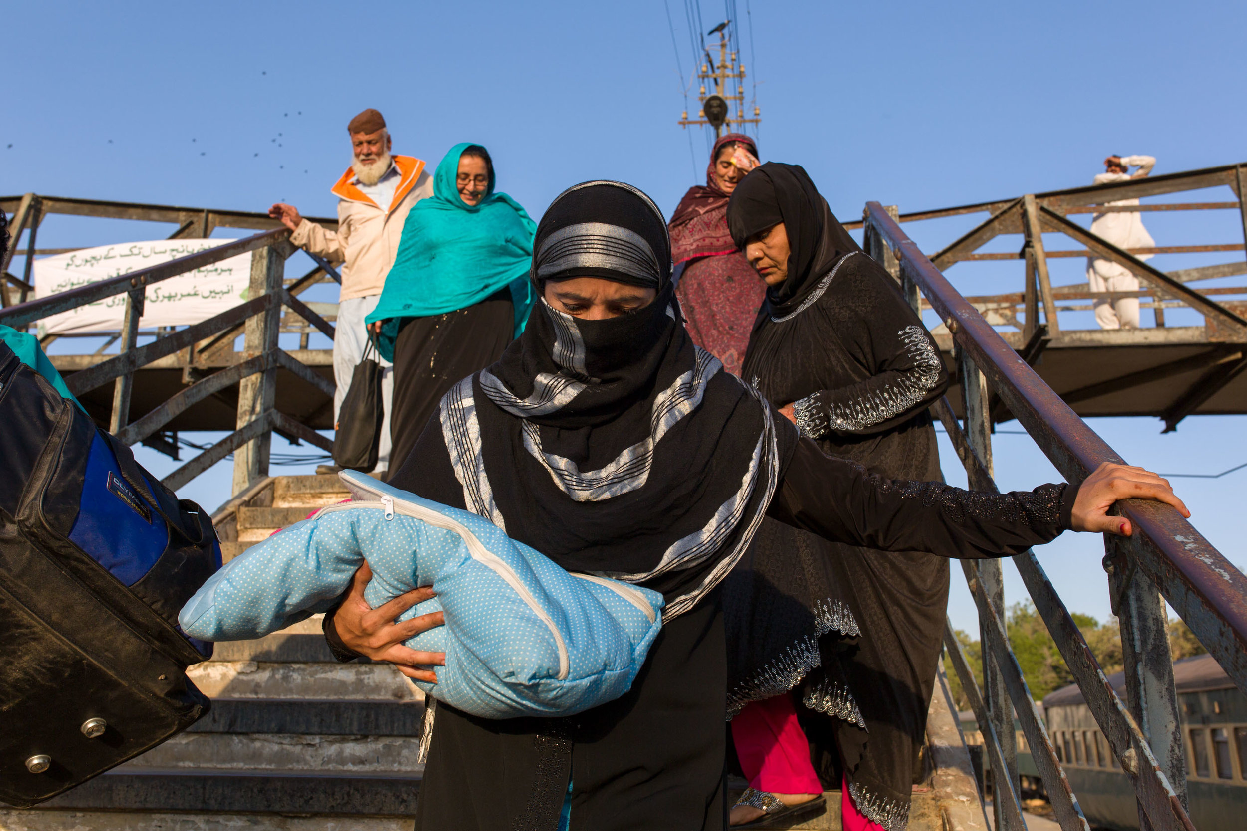 A woman carries a newborn at the Karachi train station. The baby will be vaccinated against polio by vaccinators who work on trains and station platforms. 