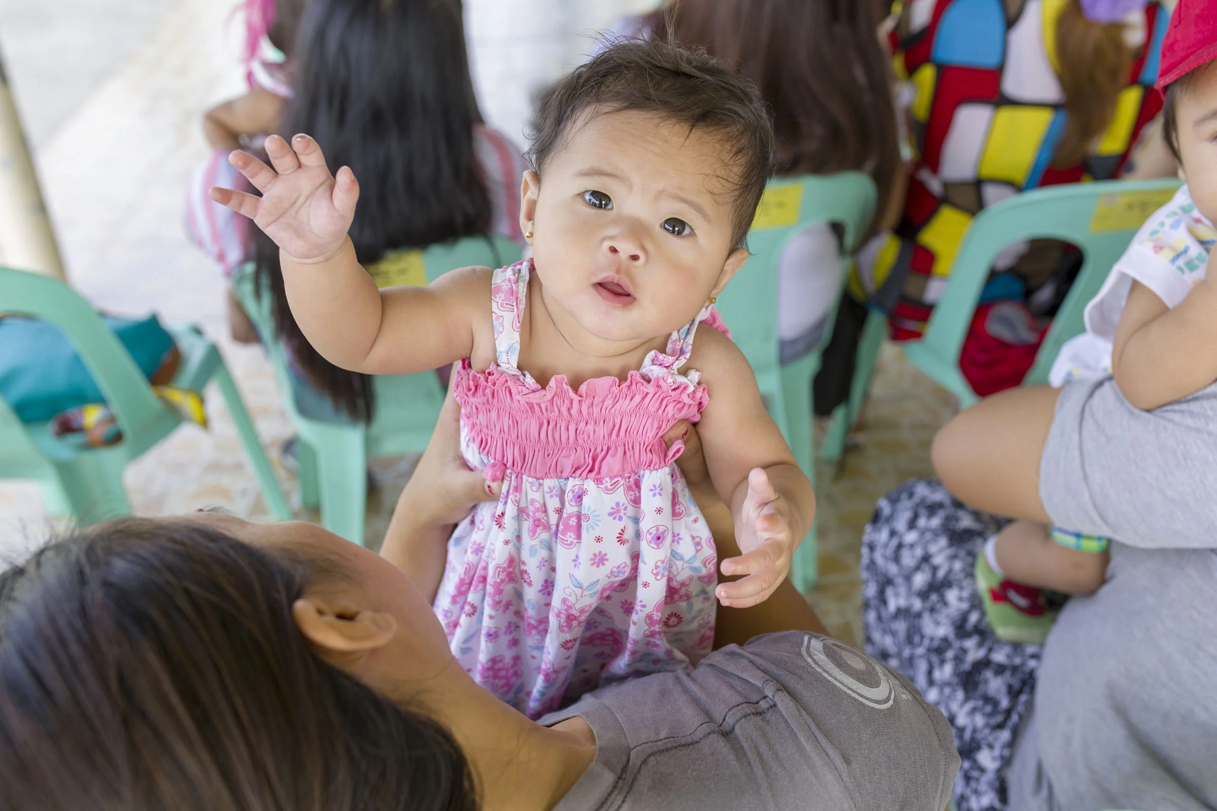  A baby waits with her mother at the health centre.  Pampanga Province, the Philippines. 