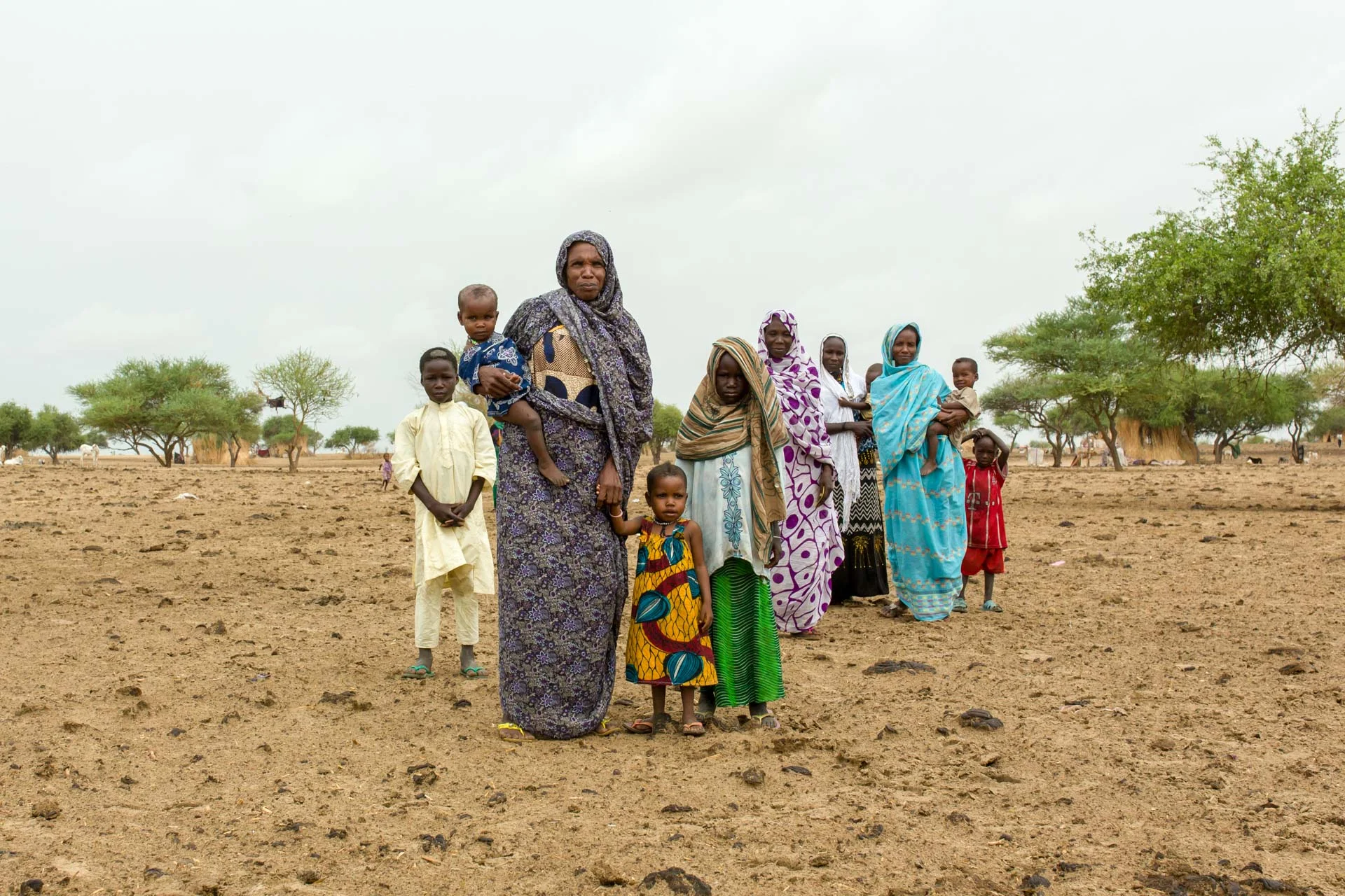 Mothers and children in a Chadian nomadic settlement walk towards a vaccination post that health workers have set up in their community. Mafou, Bol District, Chad.