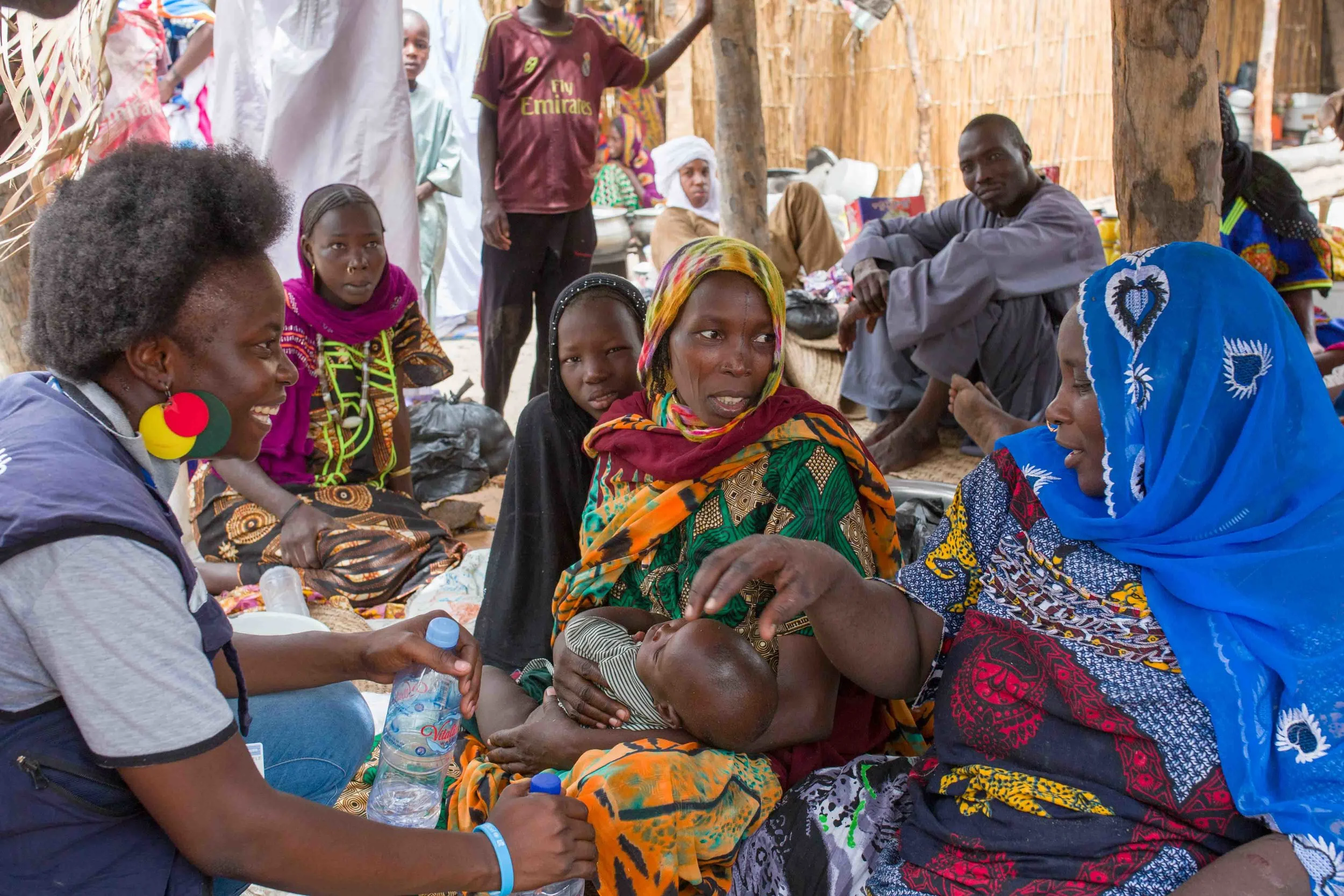  Polio consultant Dr. Adèle Aluma (with the colourful earrings) talks to local mothers at the Ngorerom island market. She asks them whether the baby has been immunized against polio.  Bol District, Chad.  