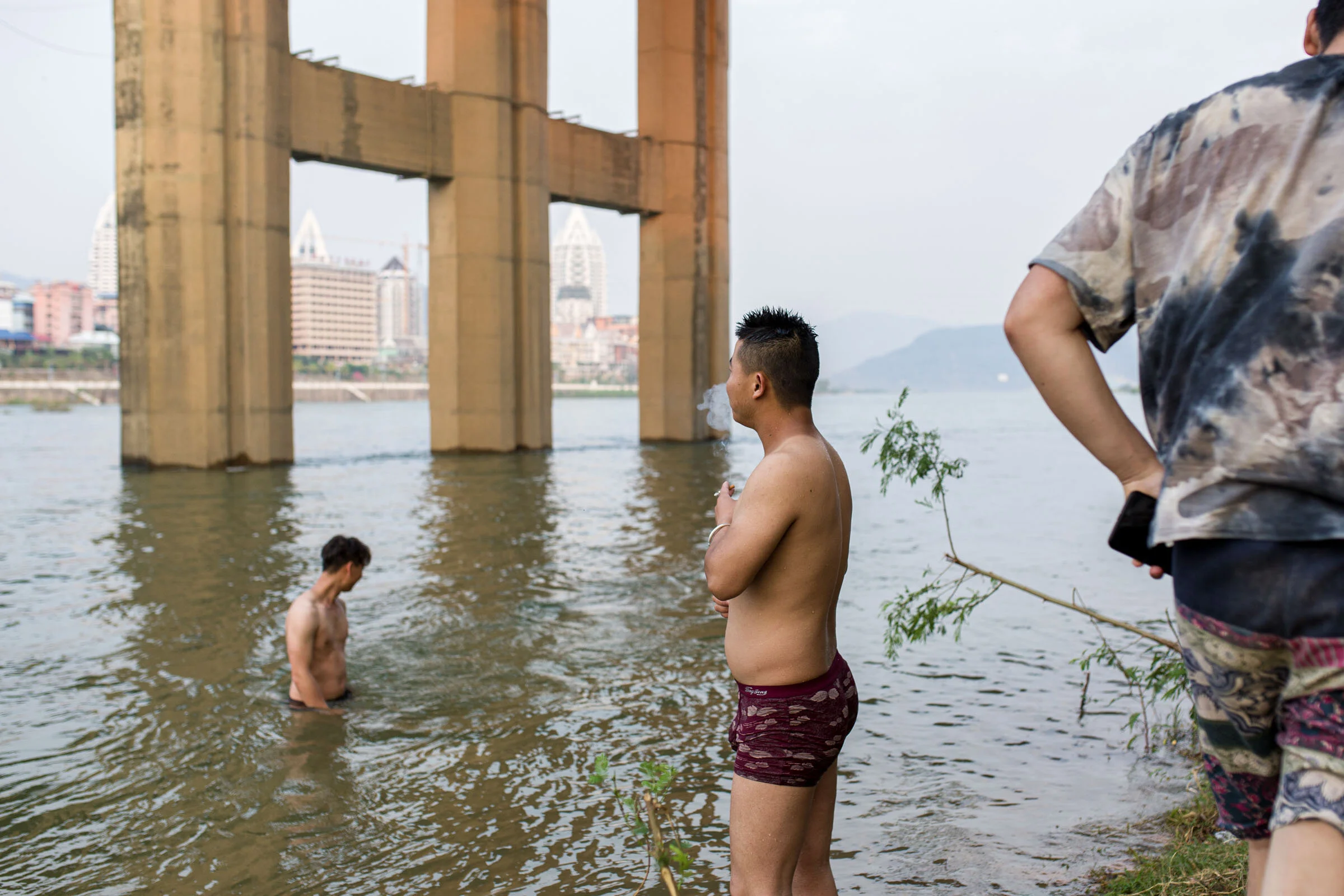  Taking a swim and cigarette break on the Mekong under the suspension bridge in Xishuangbanna, in southern Yunnan province.  