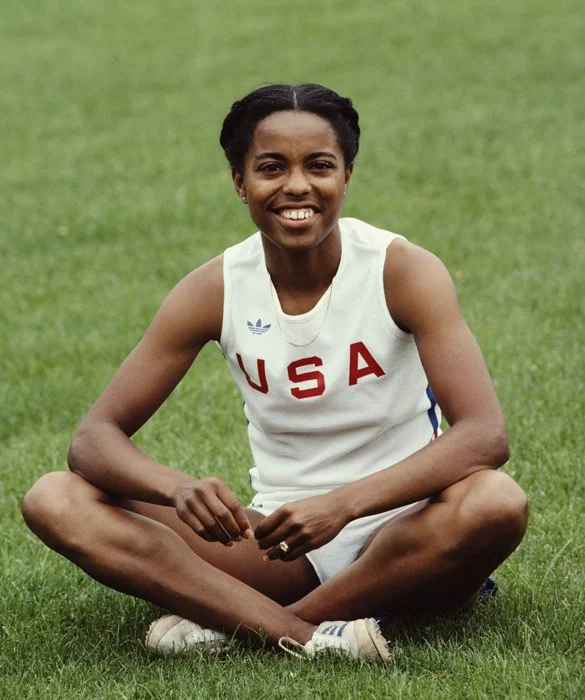Attending Roseville High School in California, Evelyn Ashford was invited to participate on the all male track team after a football coach noticed her during a phys-ed class and had her race his fastest player, saying "I think you can beat him". She did, and joined the team. She later co-captained the team during her senior year and was one of the first female athletes to receive a full athletic scholarship in the U.S. During her time at UCLA, she won four national collegiate championships. Ashford competed in four Olympic games, winning four gold medals and one silver. Ashford was named Woman Athlete of the Year in 1979. At age 35, she participated as a member of the 4x100 relay team at the 1992 Olympics, becoming the oldest woman to win an Olympic gold medal in track and field. Ashford received the Flo Hyman Award in 1989 and was inducted into the U.S. Track and Field Hall of Fame in 1997. 