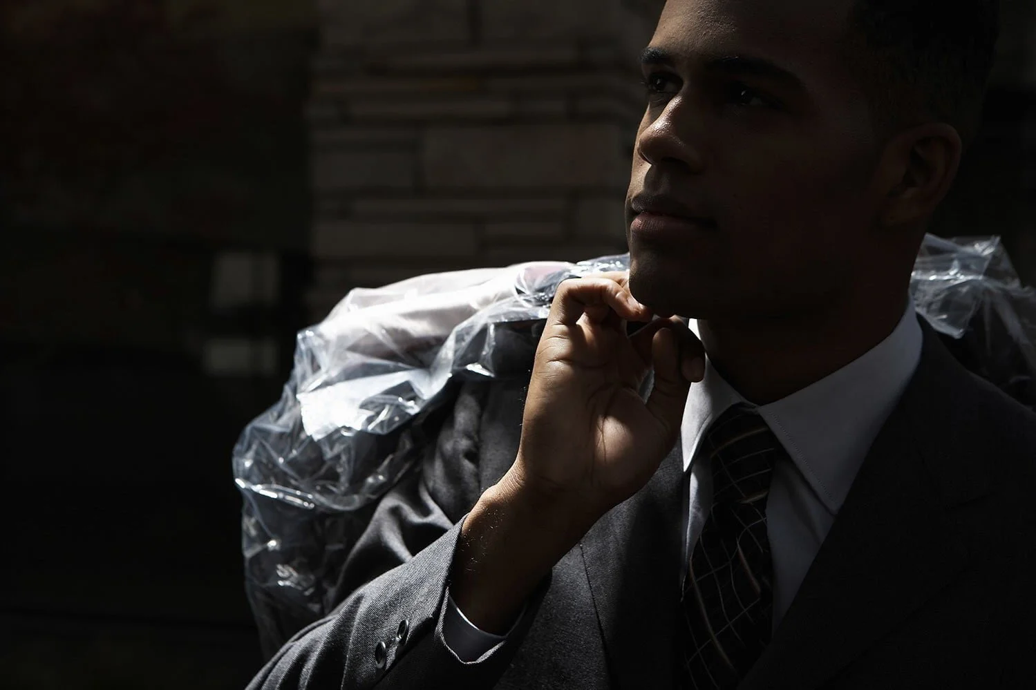 young-businessman-carrying-dry-cleaning-bag-over-shoulder-night.jpg