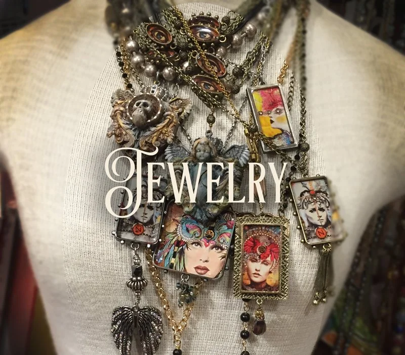 Various jewelry necklaces hanging on a mannequin, featuring large colorful portrait pendants, metallic chains, beads, and decorative charms.