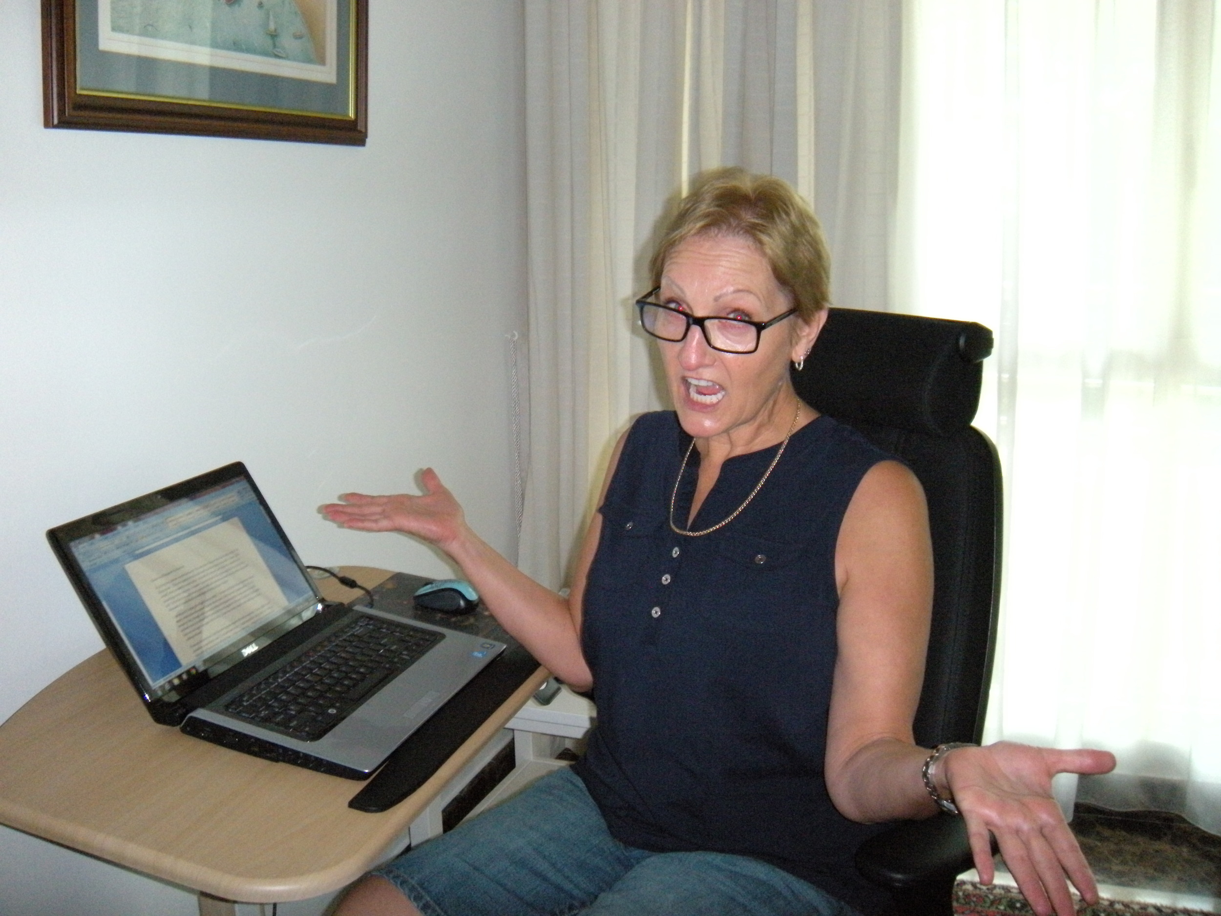 Me at my writing table, looking exaggeratedly apologetic because I forgot to take the camera in my carry-on, so no pictures