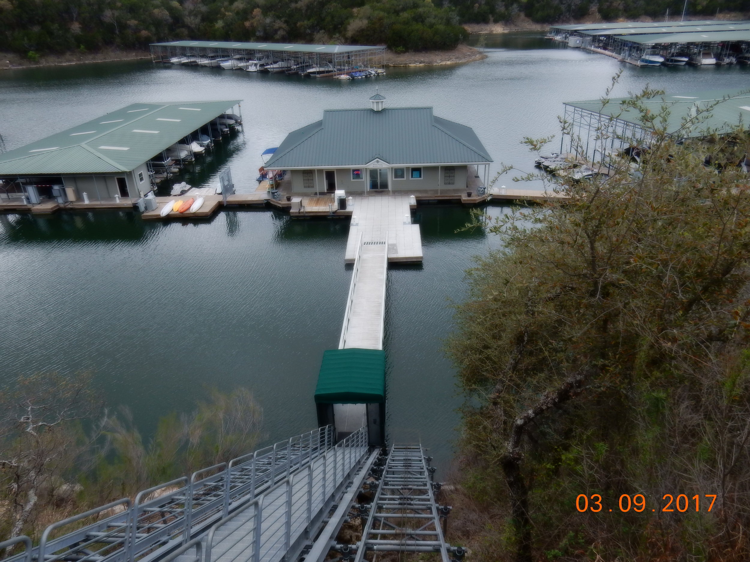 A tiny car carries people down from the yacht club and up from the marina. The lower building houses a small and ridiculously expensive shop. 