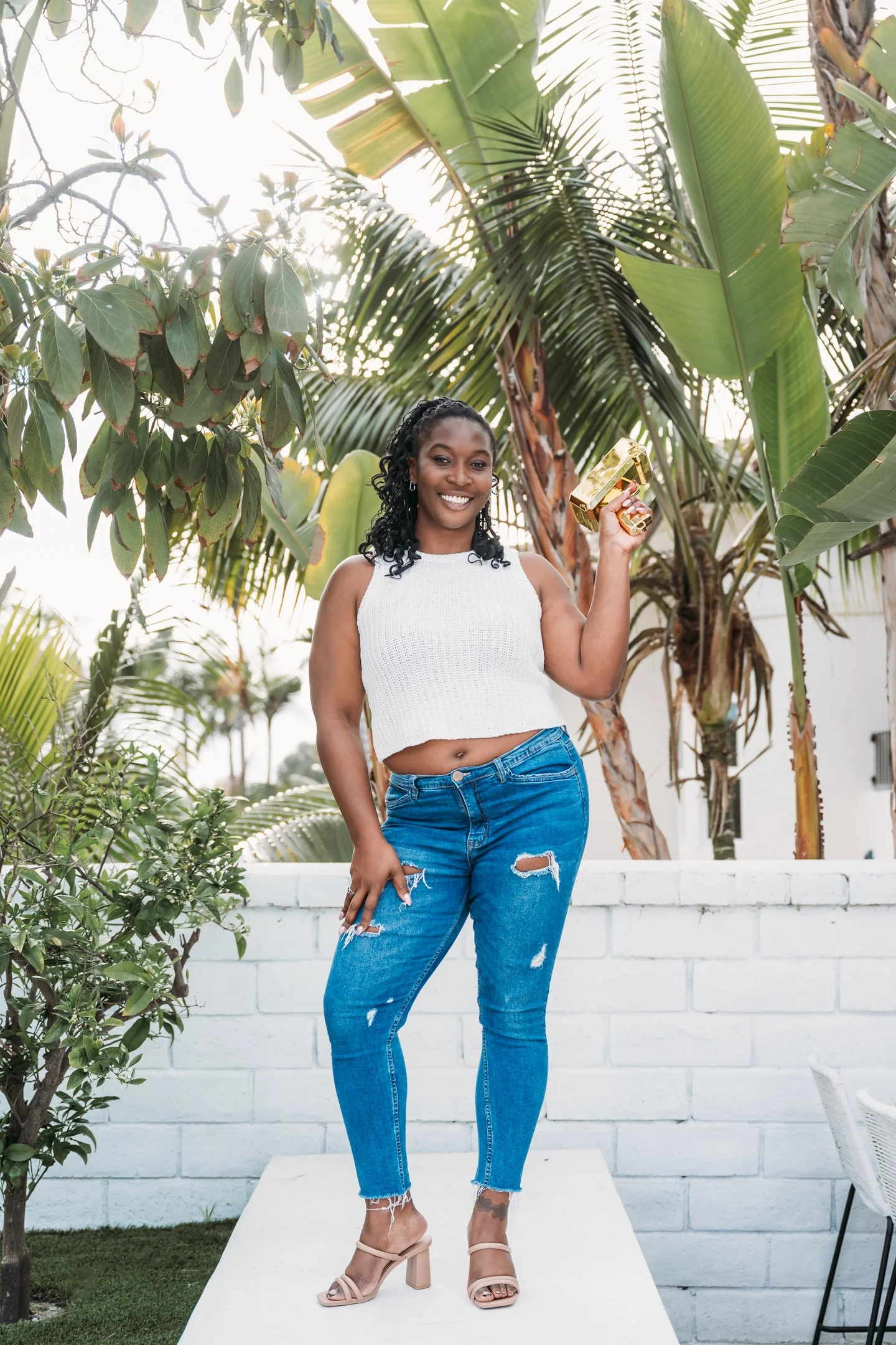 A woman standing outdoors on a white platform, holding a gold-colored trophy, smiling, Alisha Mowry Photography Military, Brand, and Portrait Photographer San Diego CA