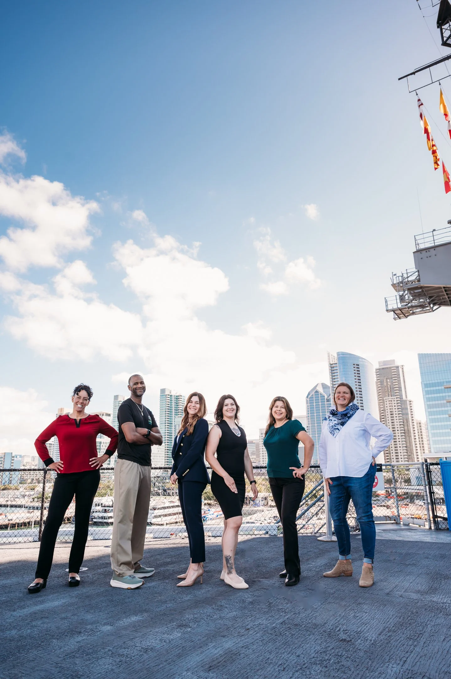 Group of six diverse individuals standing on a rooftop with a city skyline behind them, smiling and posing for the photo. Alisha Mowry Photography Military, Brand, and Portrait Photographer San Diego CA