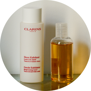 Clarins Gentle Exfoliator Brightening Toner and Pixi Glow Tonic poured into an airport-proof bottle. 