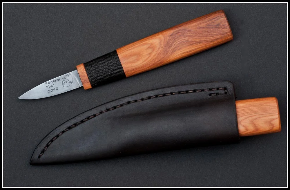 Deluxe-grade Kestrel Straight Knife in Yew wood, with logo and hand-sewn vegetable-tanned Turkish leather sheath