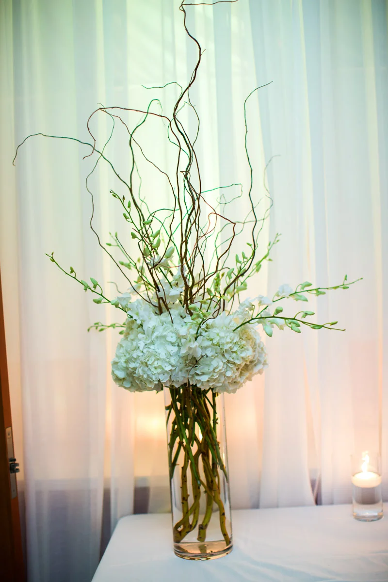 We made a tall arrangement with curly willow, white hydrangeas, white dendrobium orchids for the escort table.
