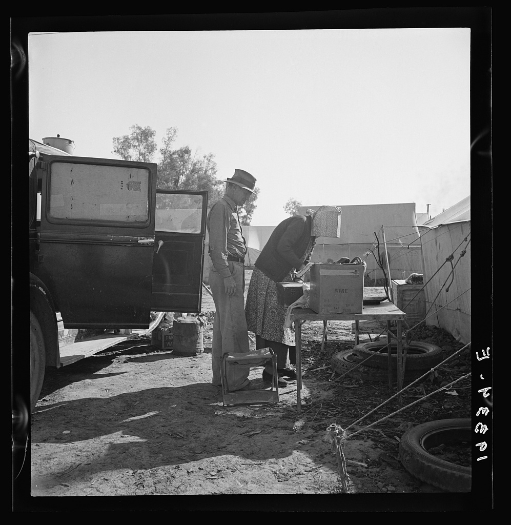  In a carrot puller' camp near Holtville, Imperial Valley, California. Migratory laborers from Texas, packing up to leave camp because of work shortage. "Don't take any pictures of us. We don't want any truck with Mr. Hearst." 