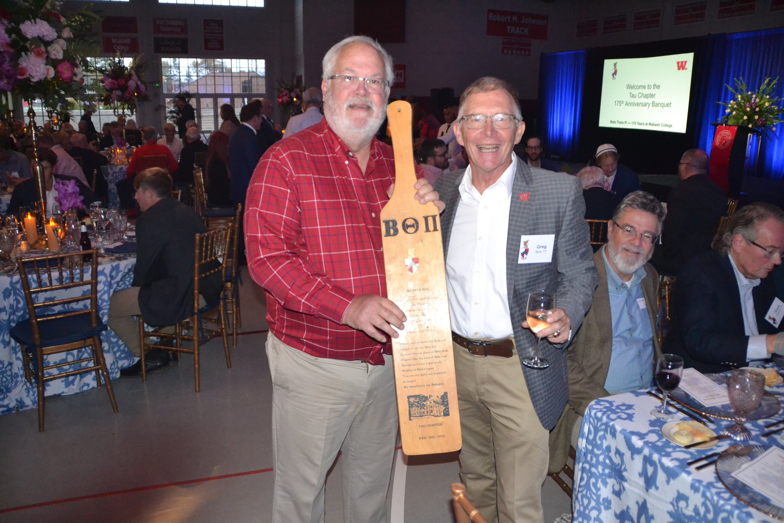  John Collins '76 and Greg Birk '77 show off an old paddle made for Pan-Hel 1965. 